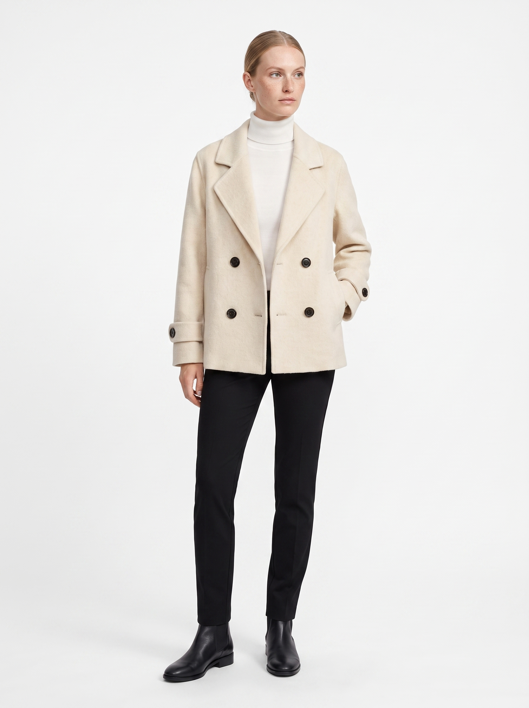 Kvinde i en creme kort oversized uldfrakke set forfra i helfigur, fotograferet i studie mod hvid baggrund — Bjerrelund