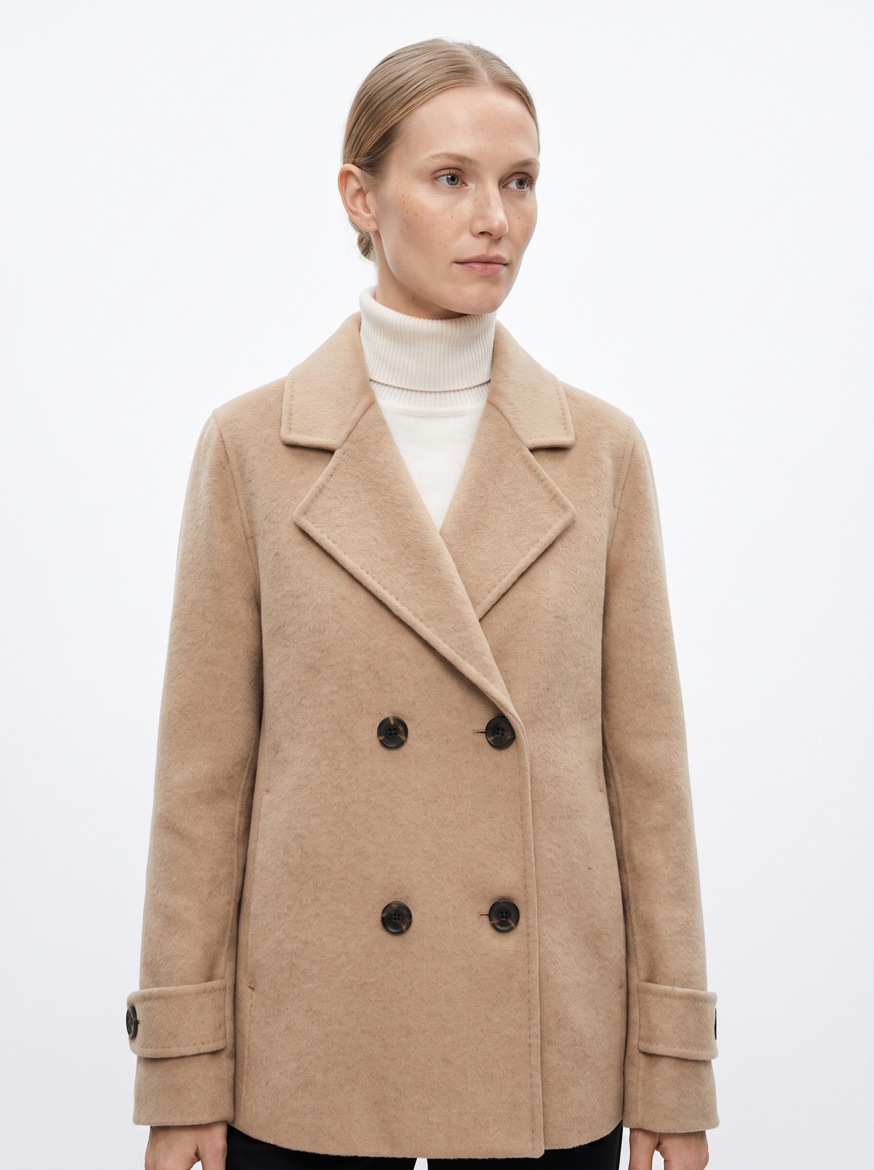 Kvinde i en beige kort oversized uldfrakke fotograferet i studie mod hvid baggrund — Bjerrelund